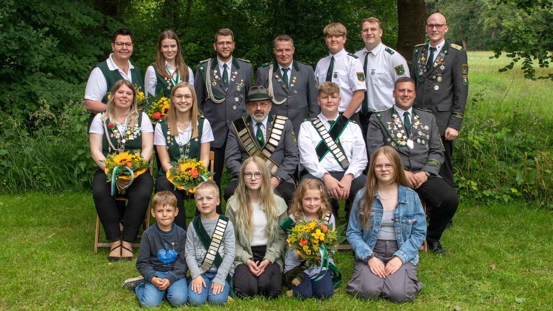 Kinder und Erwachsene posieren für ein Gruppenfoto.