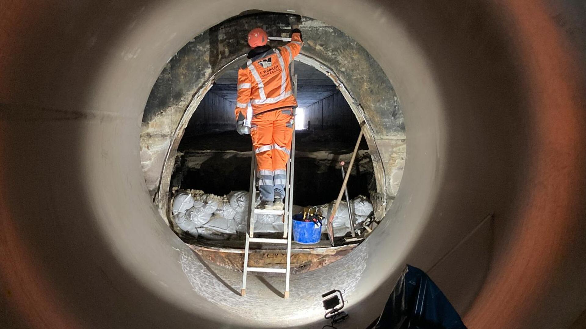 Das neue Kunststoffrohr für den Grabendurchlass schließt an einem alten Ausgang aus Beton ab. Er ist zum Teil mit Schlamm gefüllt, der noch entfernt werden muss. 