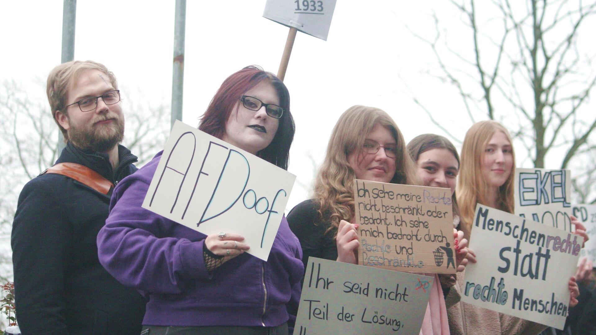 Dass die AfD ihren Kandidaten in die Podiumsdiskussion in Rotenburg entsenden darf, ruft draußen Protest hervor, der durch die Glaswand der BBS-Aula auch drinnen zu sehen ist. 