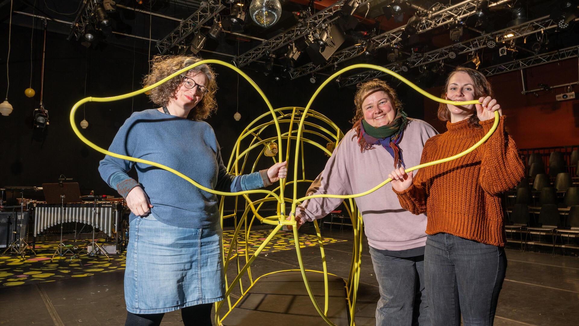 Den Fisch haben die Schlosser im Stadttheater als Klettergerüst selbst hergestellt. Bianca Sue Henne (Dramaturgie), Lisa Fütterer (Bühne und Kostüme) und Annika Ellen Flindt (v. links) freuen sich auf die Kinderoper „Gold!“ im JUB!.