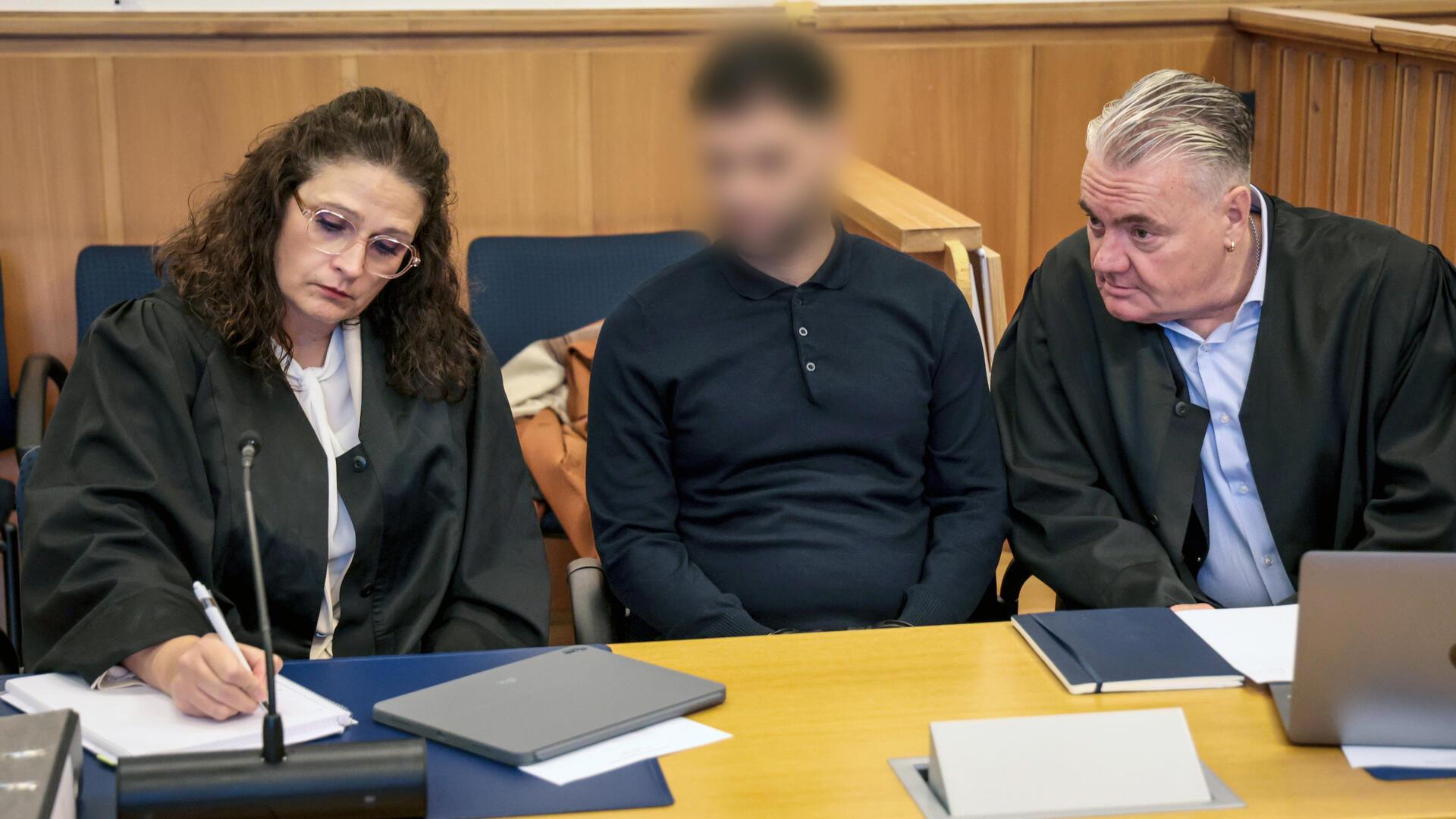 Der 34-jährige Angeklagte sitzt zu Prozessbeginn zwischen seinen Anwälten Dinah Busse und Dirk Meinicke in einem Verhandlungssaal des Landgerichts.