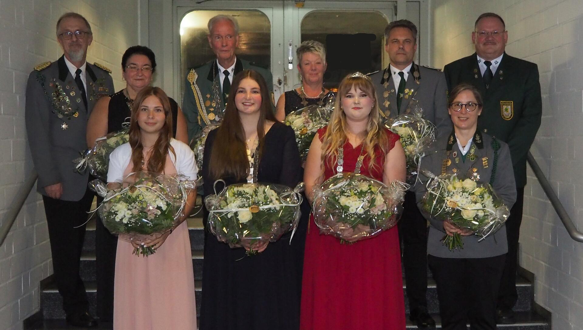 Gruppenfoto von sechs Frauen und vier Männern auf einer Treppe.