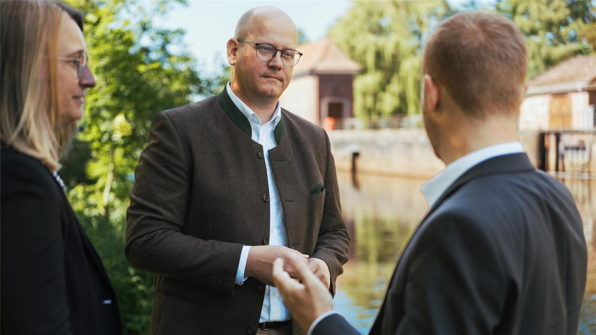 Das Foto zeigt Marco Mohrmann im Gespräch mit zwei Personen. 