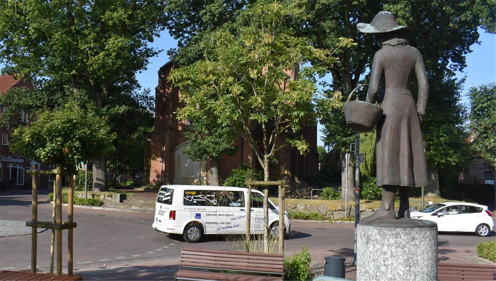 Ein Bus, ein Auto und eine Skulptur