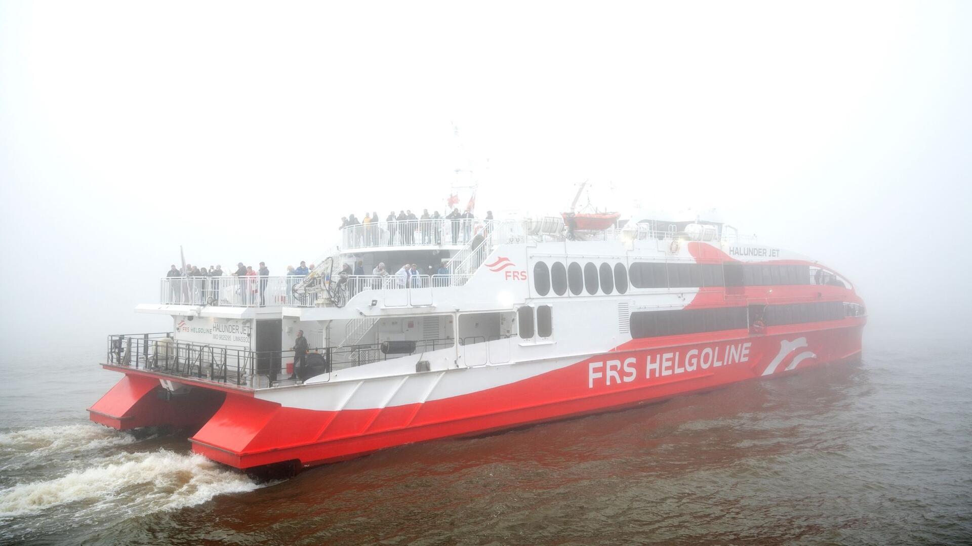 Der Helgoland-Katamaran „Halunder Jet“ legt am Morgen im dichten Nebel im Hafen auf der Elbe in Richtung der Nordseeinsel Helgoland ab.