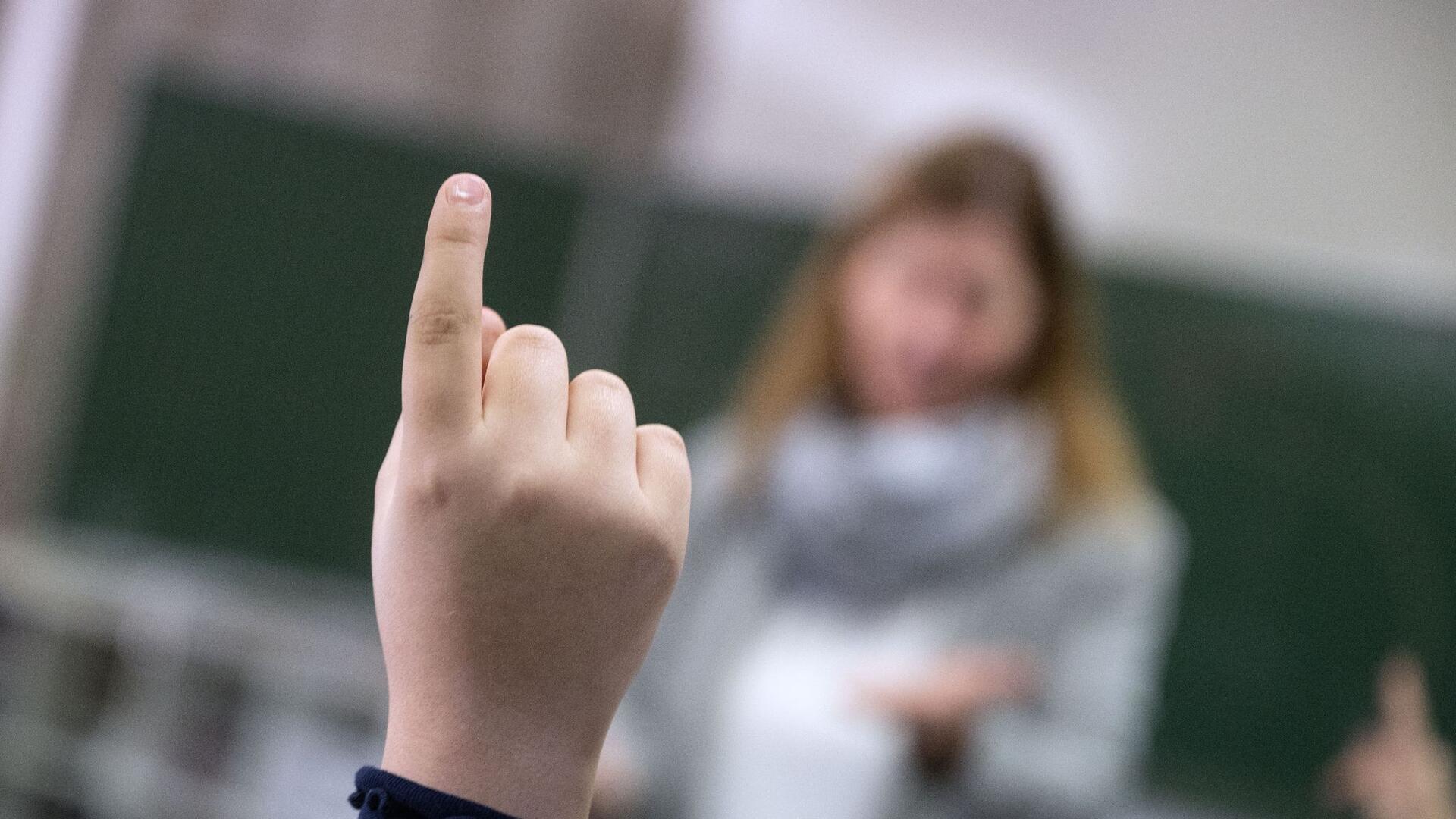 Ein Schüler meldet sich in einer Klasse im Unterricht zu Wort.