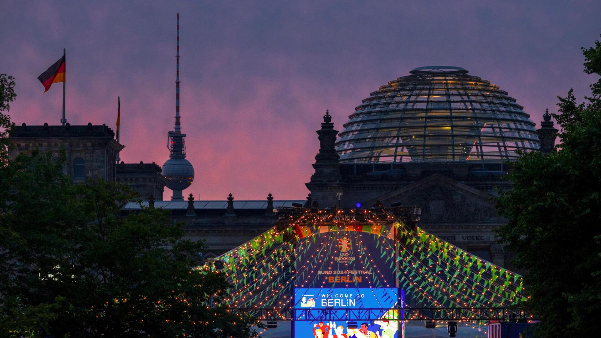 Der Schriftzug „Welcome to Berlin“ ist kurz vor Sonnenaufgang auf einem Bildschirm der Fanzone (Platz der Republik) vor der Kulisse des Reichstages und des Fernsehturmes zu lesen. Die Europameisterschaft findet vom 14. Juni bis 14. Juli statt.