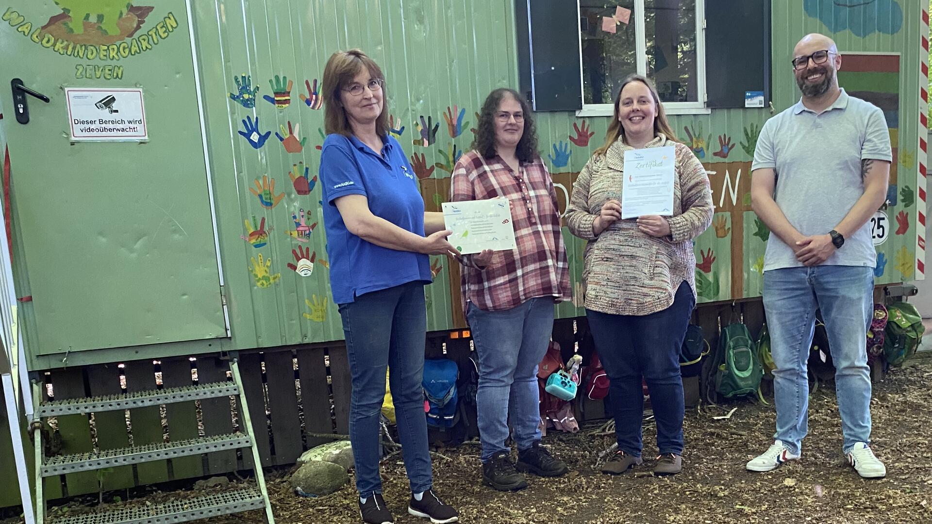 Der Waldkindergarten Zeven freut sich über eine Zertifizierung für seine Umweltbildung durch die NABU Umweltpyramide, von links: Bettina Schroeder (NABU), Lena Fitschen, Jana Konrad, Fachdienstleiter Sebastian Kluge (Samtgemeindeverwaltung Zeven).