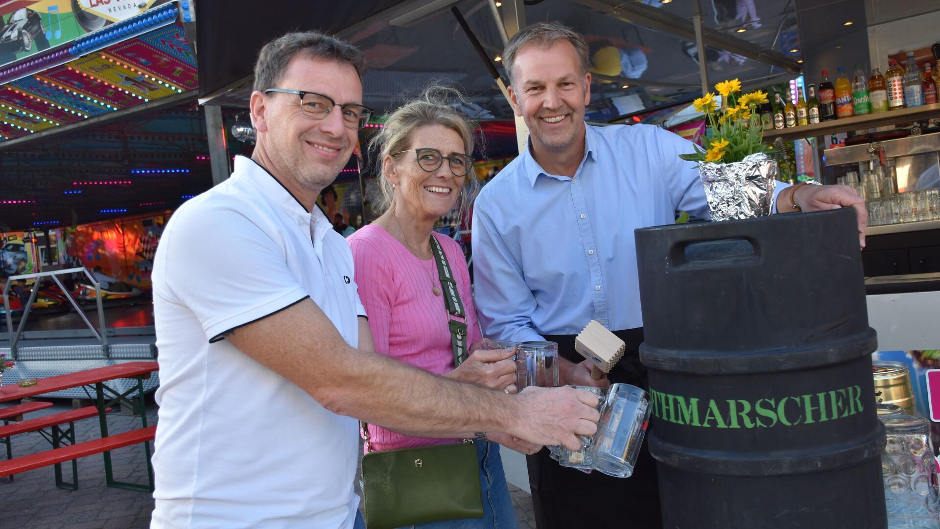 Drei Menschen an einem Bierfass