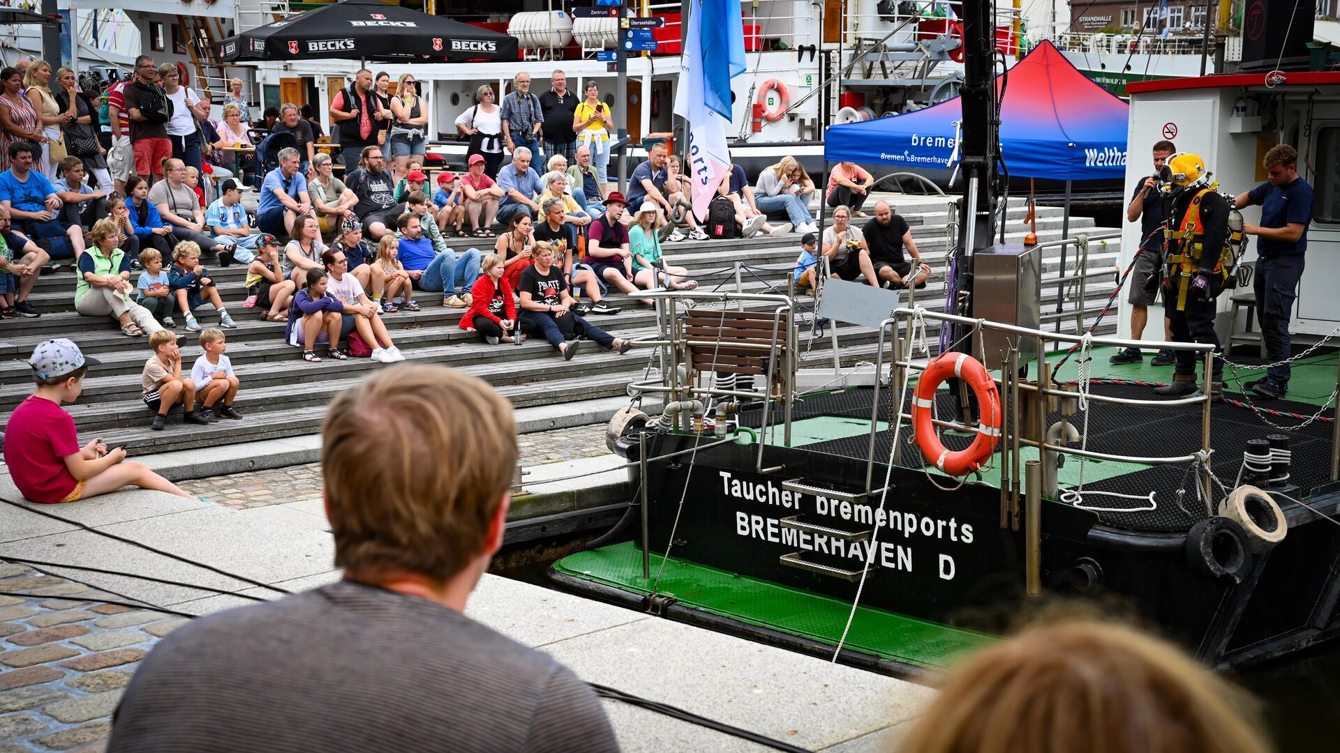 Der erste der Maritimen Tage lässt sich gut an. Wenn die Taucher von Bremenports ins Wasser steigen, sind immer viele Interessenten dabei. Die Männer in ihren Tauchanzügen ziehen halt.