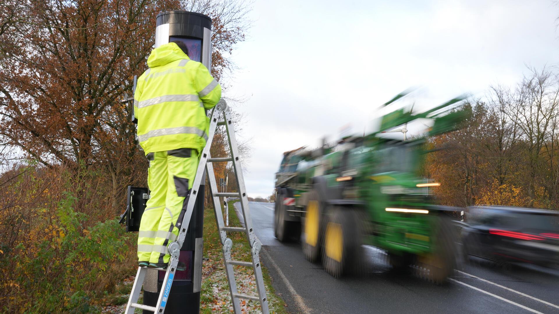 Ein Mann arbeitet an einem Blitzer an der L119 in Neuenwalde.