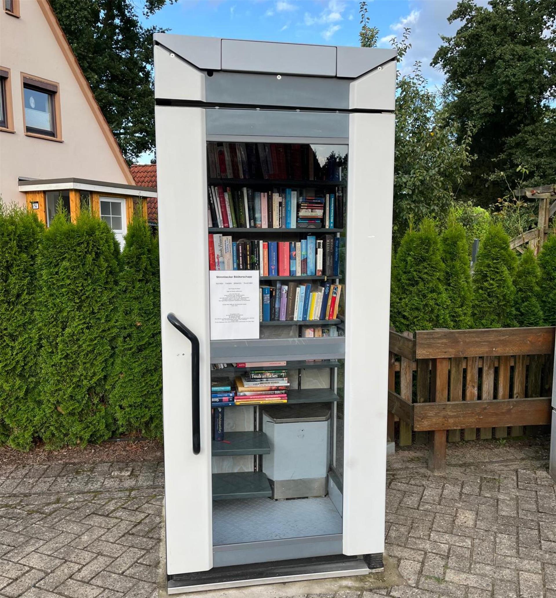 Eine graue Telefonzelle mit Büchern