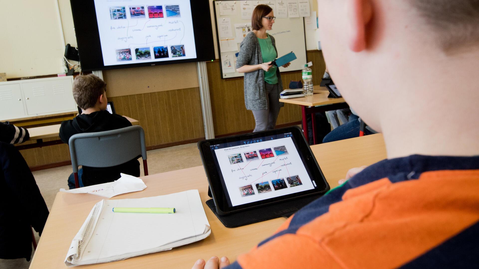 Schüler lernen mit iPads im Unterricht. 