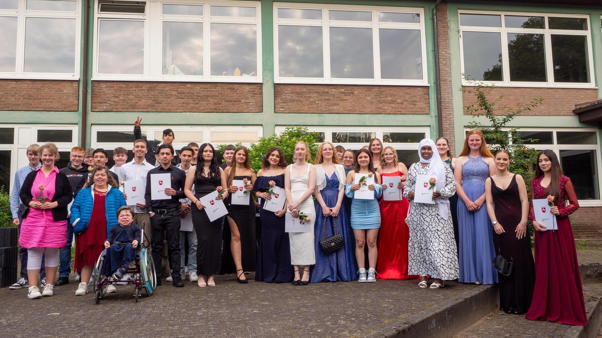 Die Abschlussschülerinnen und -schüler der 9. Klassen und der Helga-Leinung-Schule stellen sich für den Fotografen auf. 