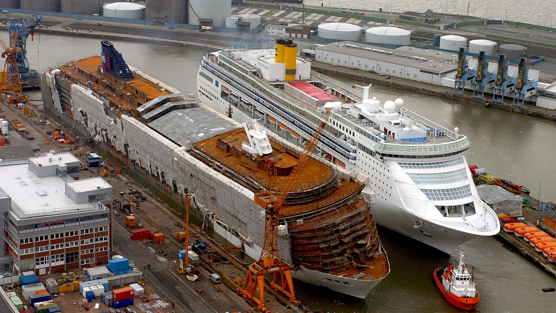 Zwei Kreuzfahrtschiffe nebeneinander im Hafen.