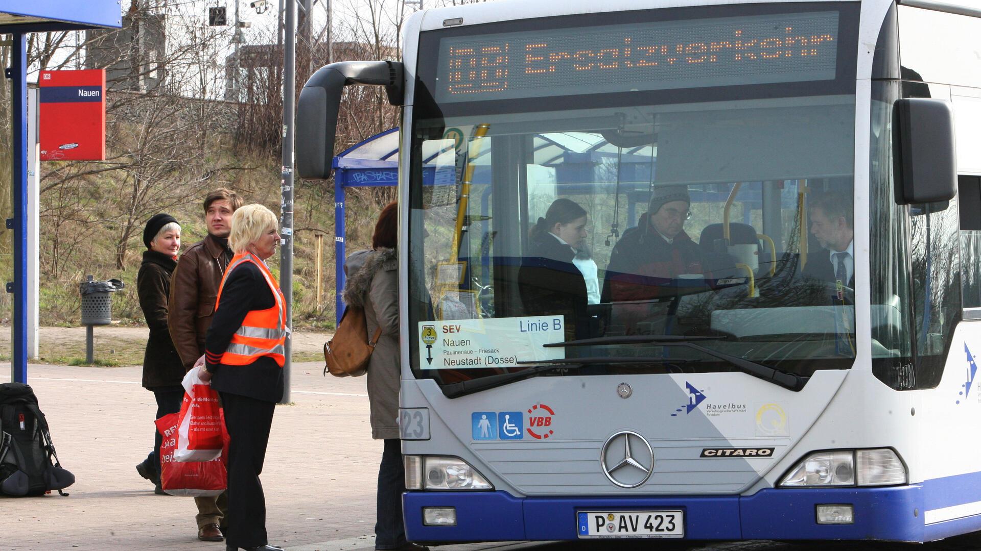 Leute steigen am Bahnhof in einen Bus um. 