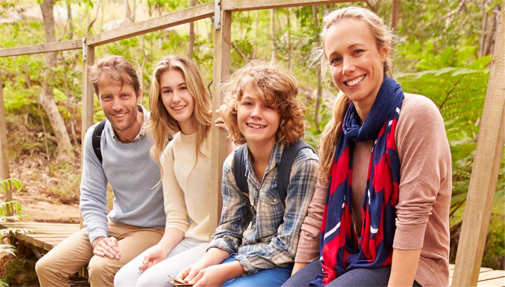 Eine Familie sitzt auf einer Holzbrücke