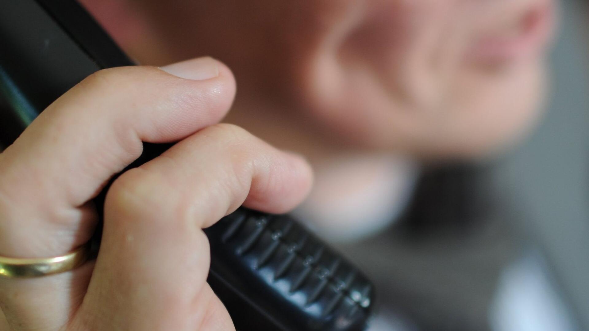 Frau mit Telefonhörer in der Hand