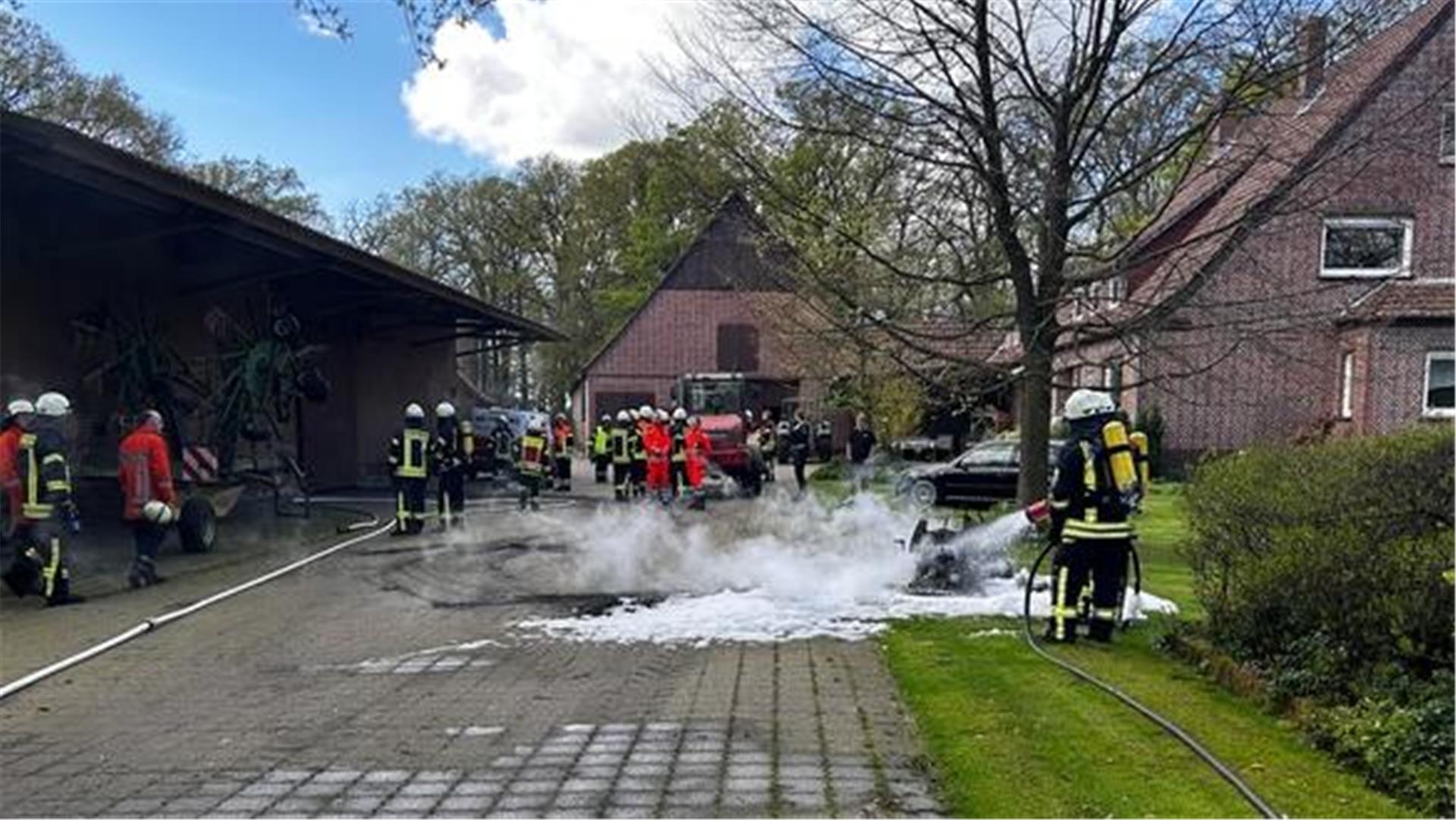 Die Feuerwehr beim Ablöschen des Aufsitzmähers