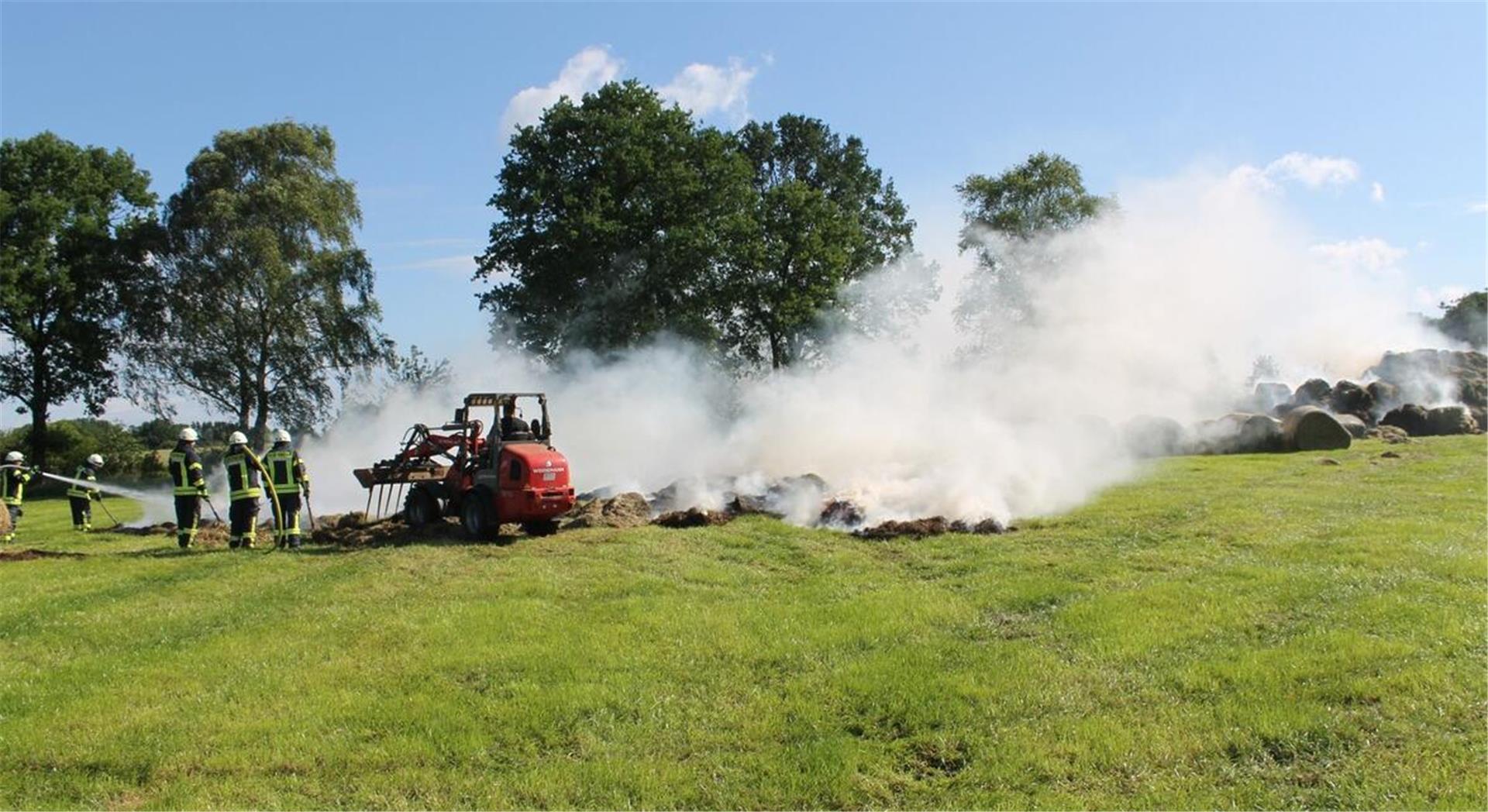 Die Feuerwehr löscht die Heuballen in der Feldmark in Ostereistedt mit Hilfe von Landwirten.