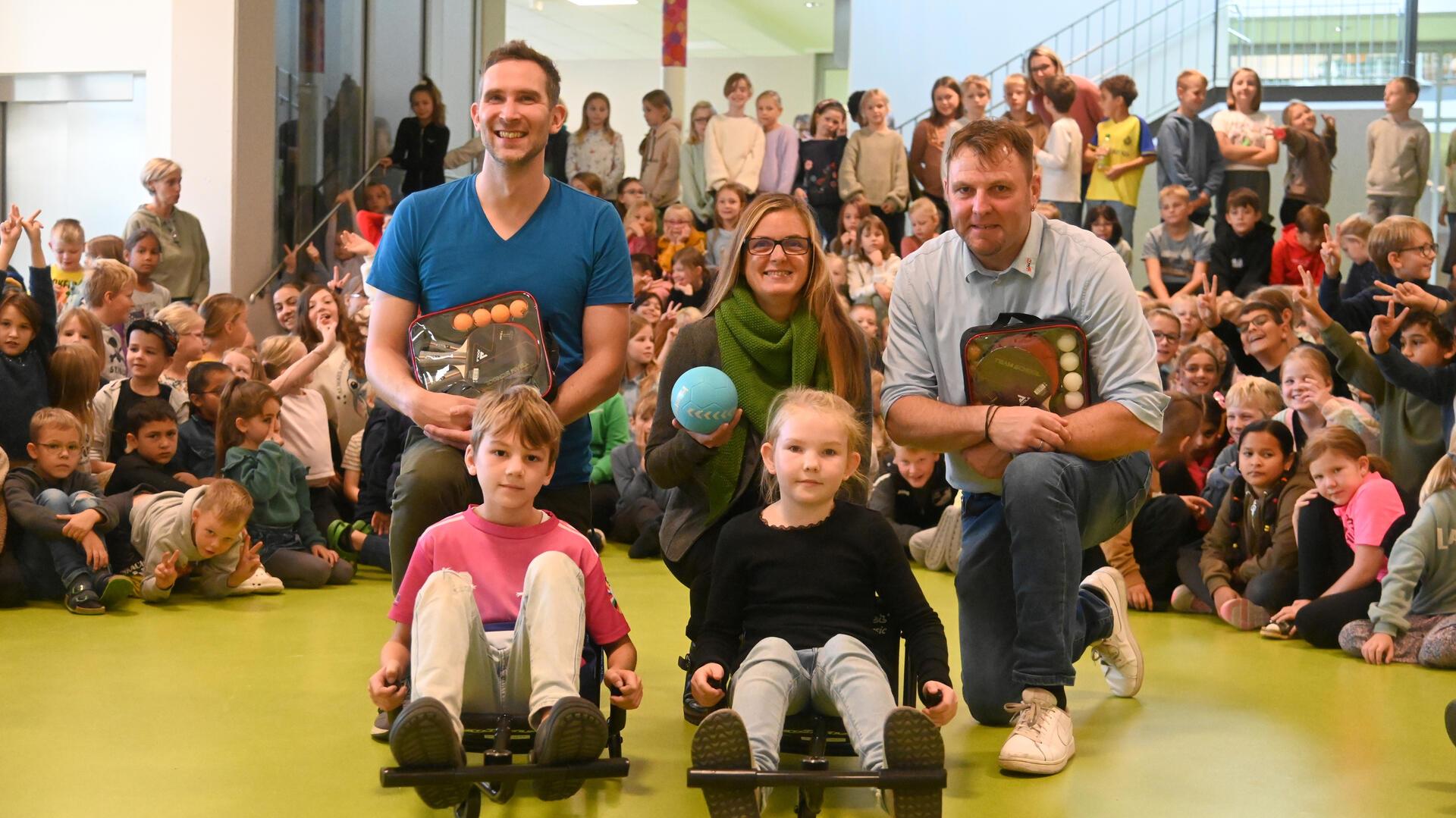 Die Förderverein-Vorstandsmitglieder Matthias Bohlmann (re.) und Sandra Pragmann überreichten Schulleiter Malte Müller-Cordes einen Teil der neuen Spielgeräte. Im Fundus sind künftig unter anderem auch sogenannte Ezyroller.