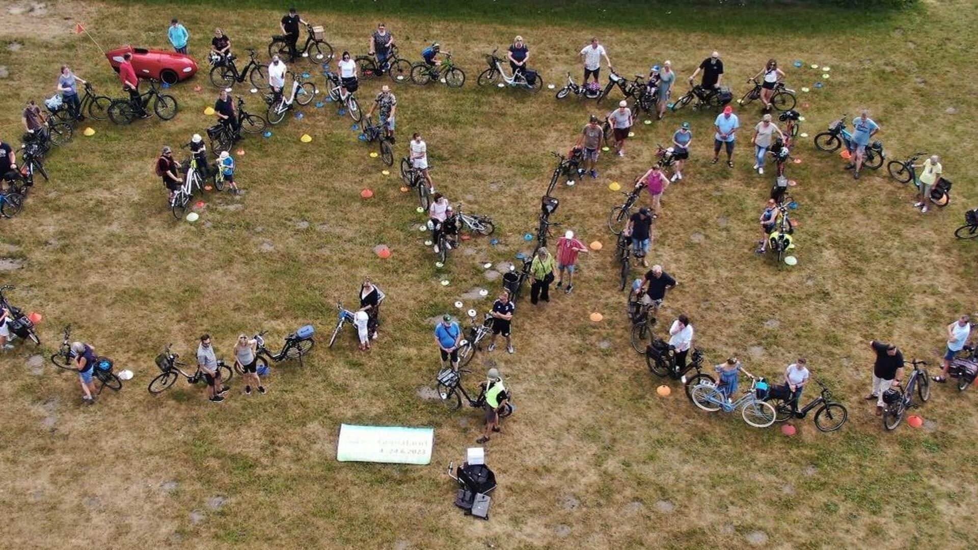 Die Geestländer radelten 2023 am weitesten. Zum Abschluss bildeten rund 50 Teilnehmer auf dem Sportplatz des TV Langen ein Fahrrad.