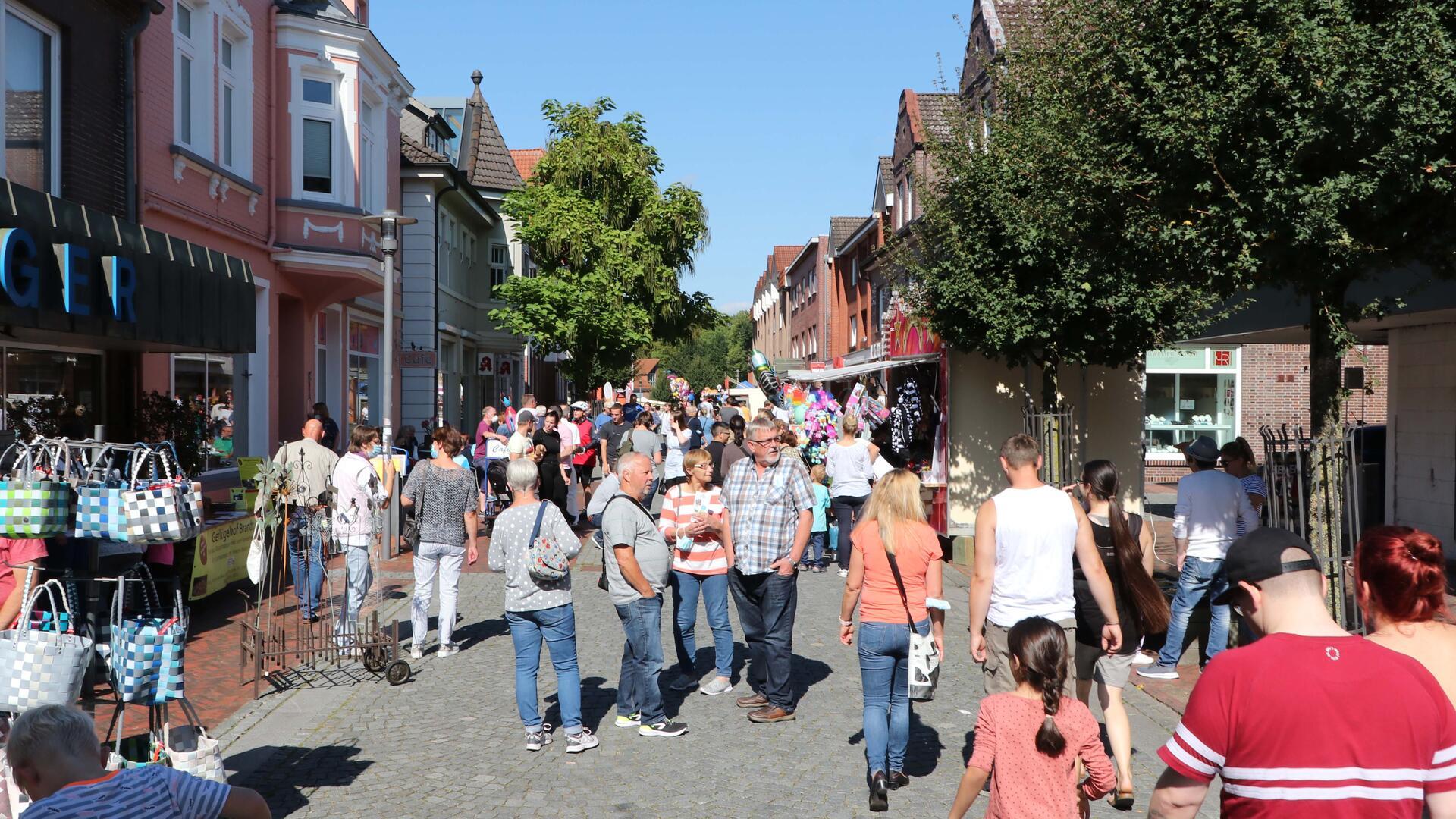 Menschen in sommerlicher Kleidung auf einer Straße