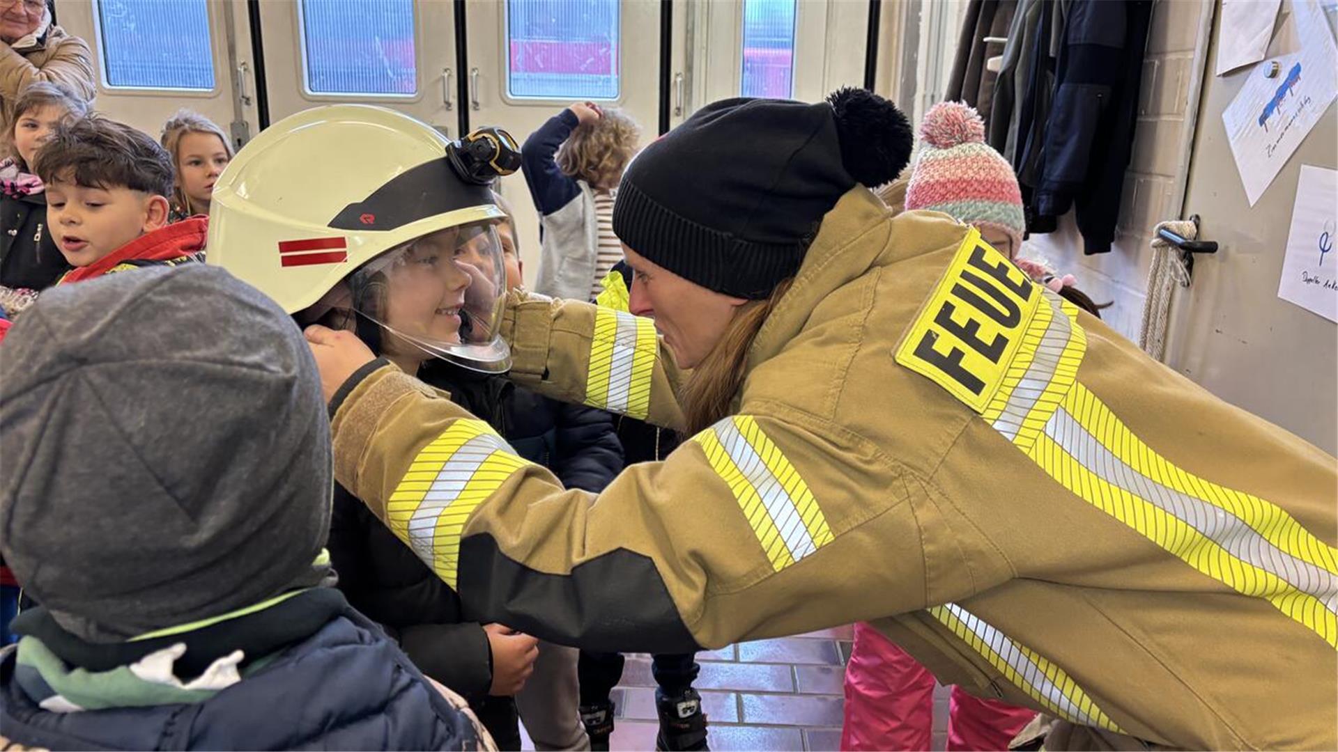 Die Kinder bekamen die Ausrüstung der Feuerwehr gezeigt und durften natürlich auch mal einen echten Feuerwehrhelm aufsetzen.