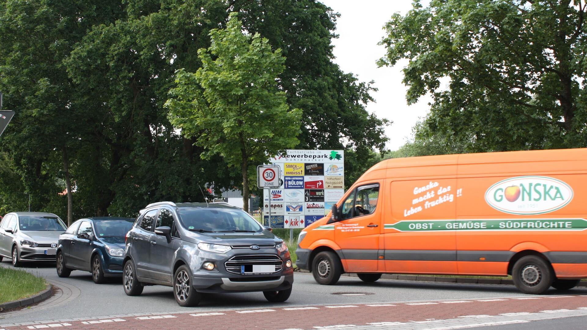 Drei Pkw und ein Lieferwagen begegnen sich im Straßenverkehr an einer Kreuzung