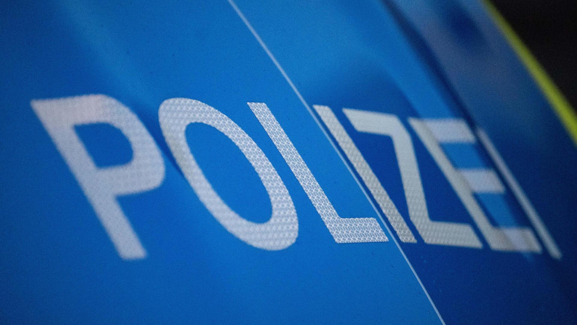 Schriftzug Polizei auf blauem Hintergrund.