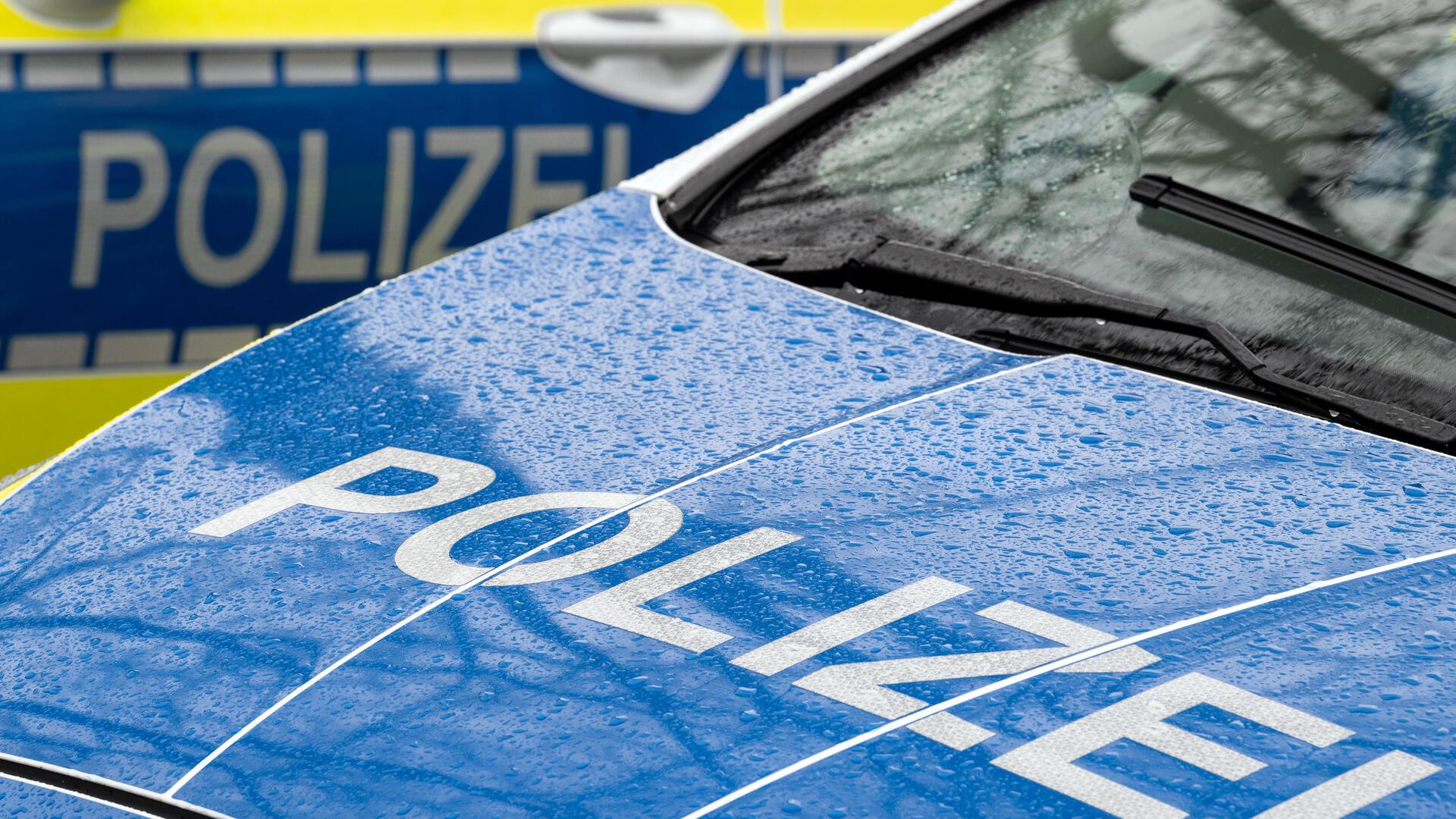 Eine blaue Motorhaube eines Autos und der Schriftzug Polizei.