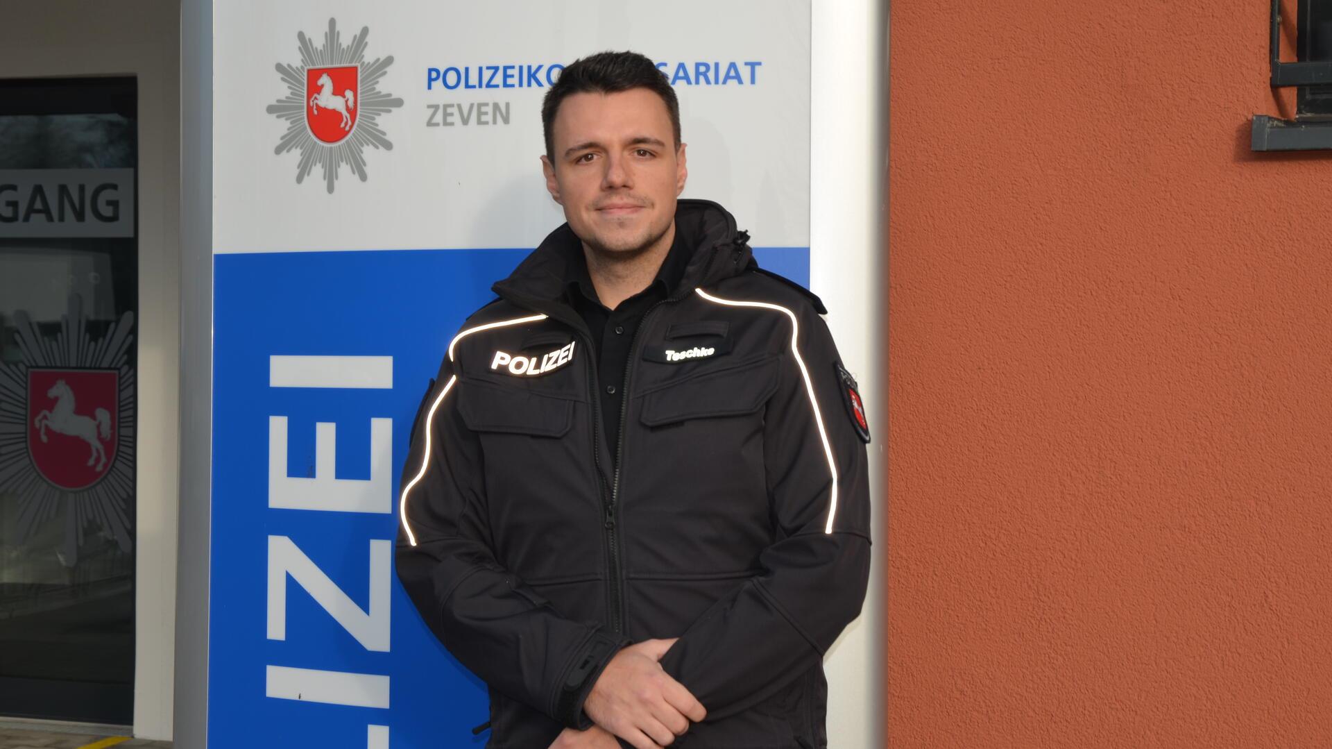 Ein Mann in Polizeiuniform schaut lächelnd in die Kamera. 