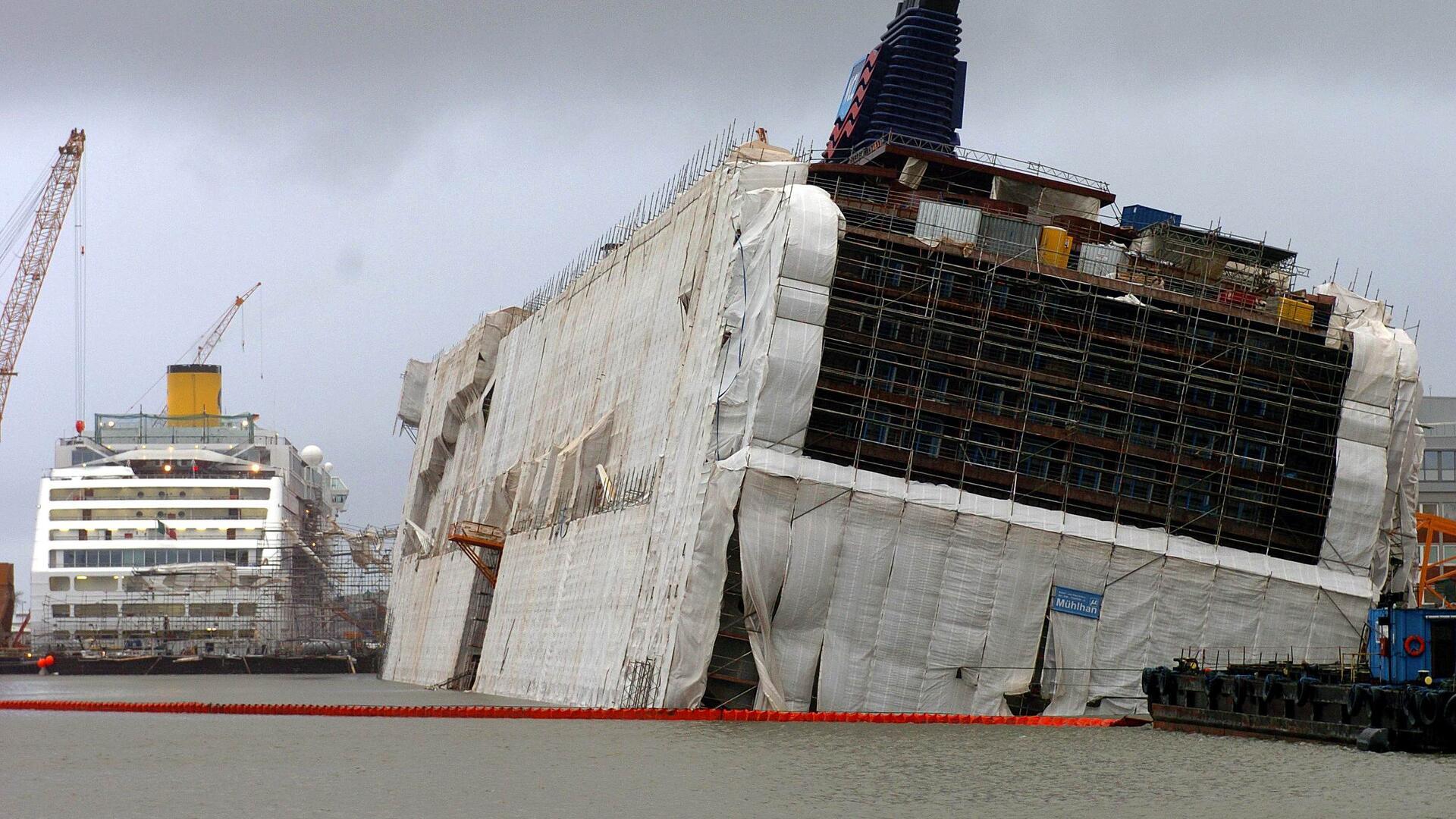 Schiff liegt schief auf dem Grund des Hafenbeckens.