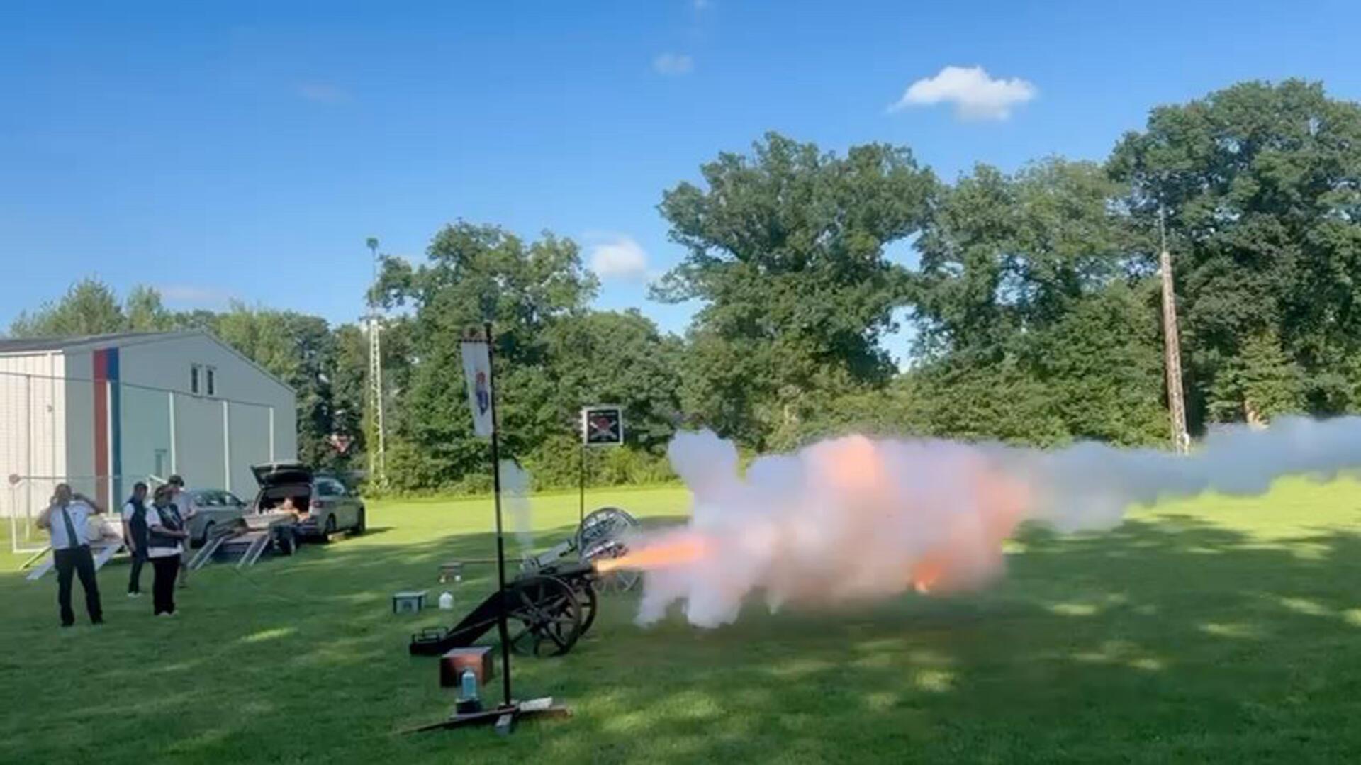 Eine Kanone feuert auf offenem Feld Schüsse ab.