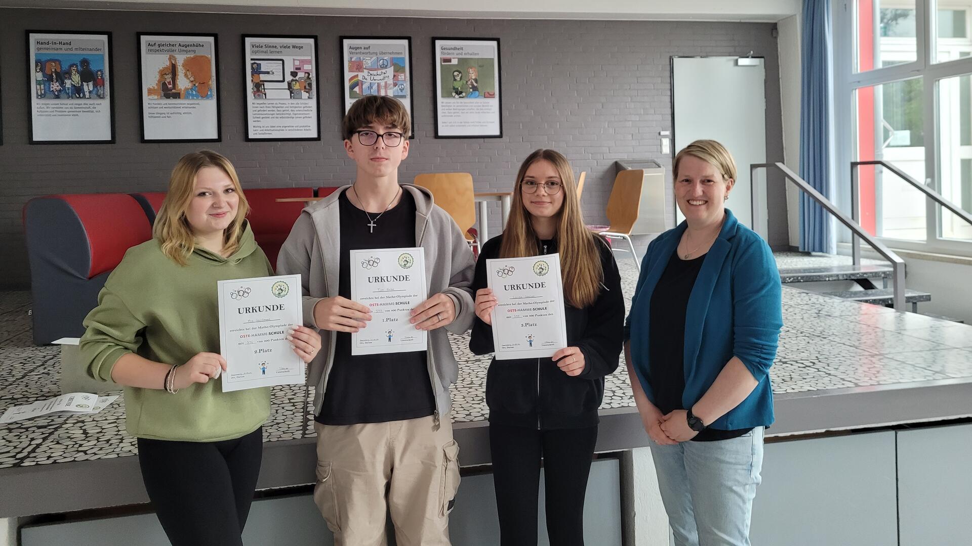 Die Siegerinnen und Sieger Mia Grundmann (von links, 2. Platz), Tom Hieke (1. Platz), Louisa Gehlken (3. Platz), Jennifer Krause (Fachkonferenzleitung Mathematik).