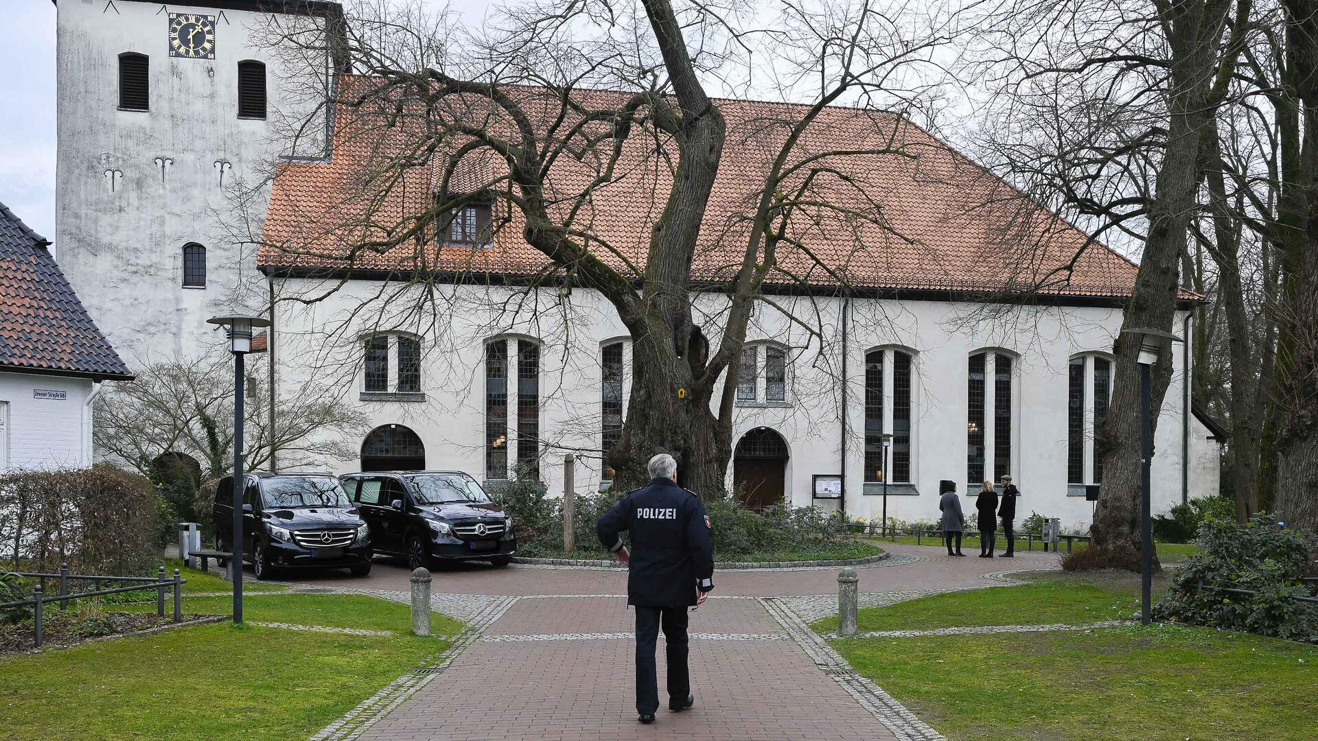 Die St.-Lucas-Kirche in Scheeßel am Freitagmittag: Beamte der Polizeiinspektion Rotenburg sind vor Ort, um die Trauerfeier für die beiden Opfer aus Westervesede eng zu begleiten.