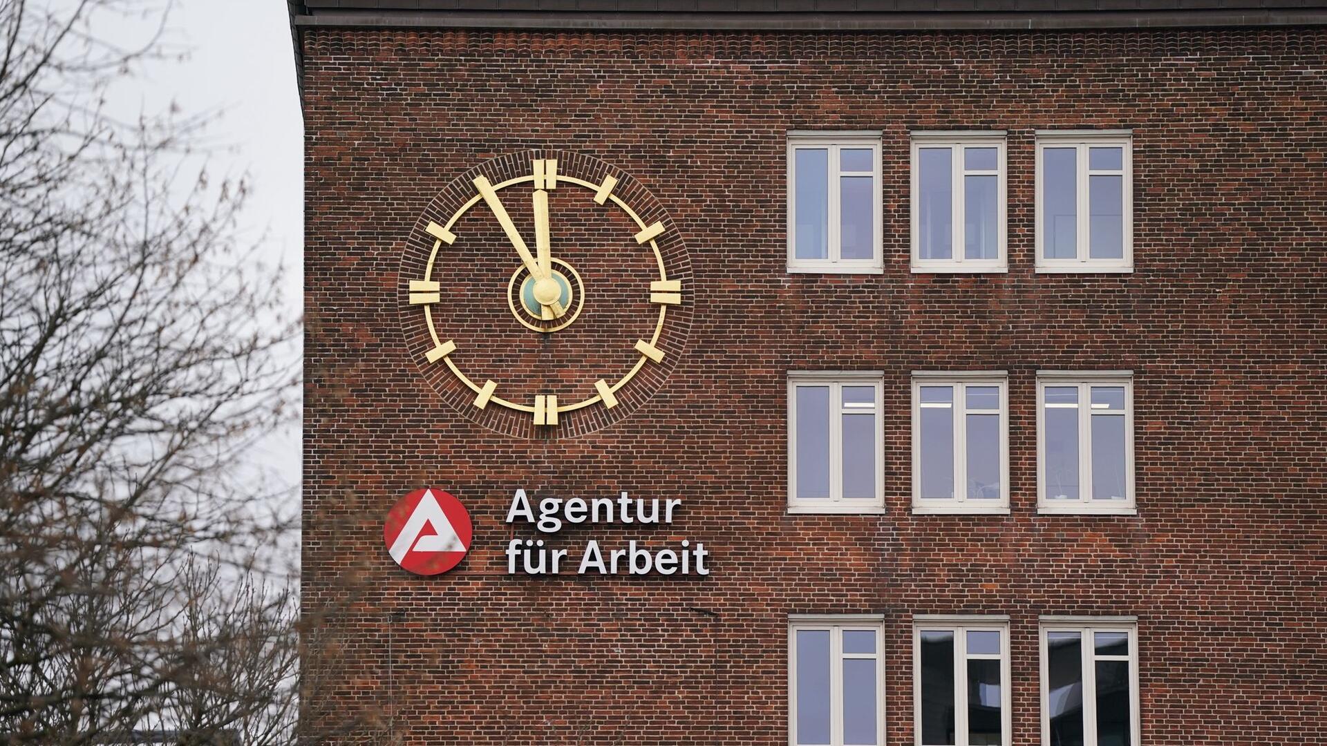 Die Uhr an der Fassade der Agentur für Arbeit zeigt fünf Minuten vor Zwölf an.