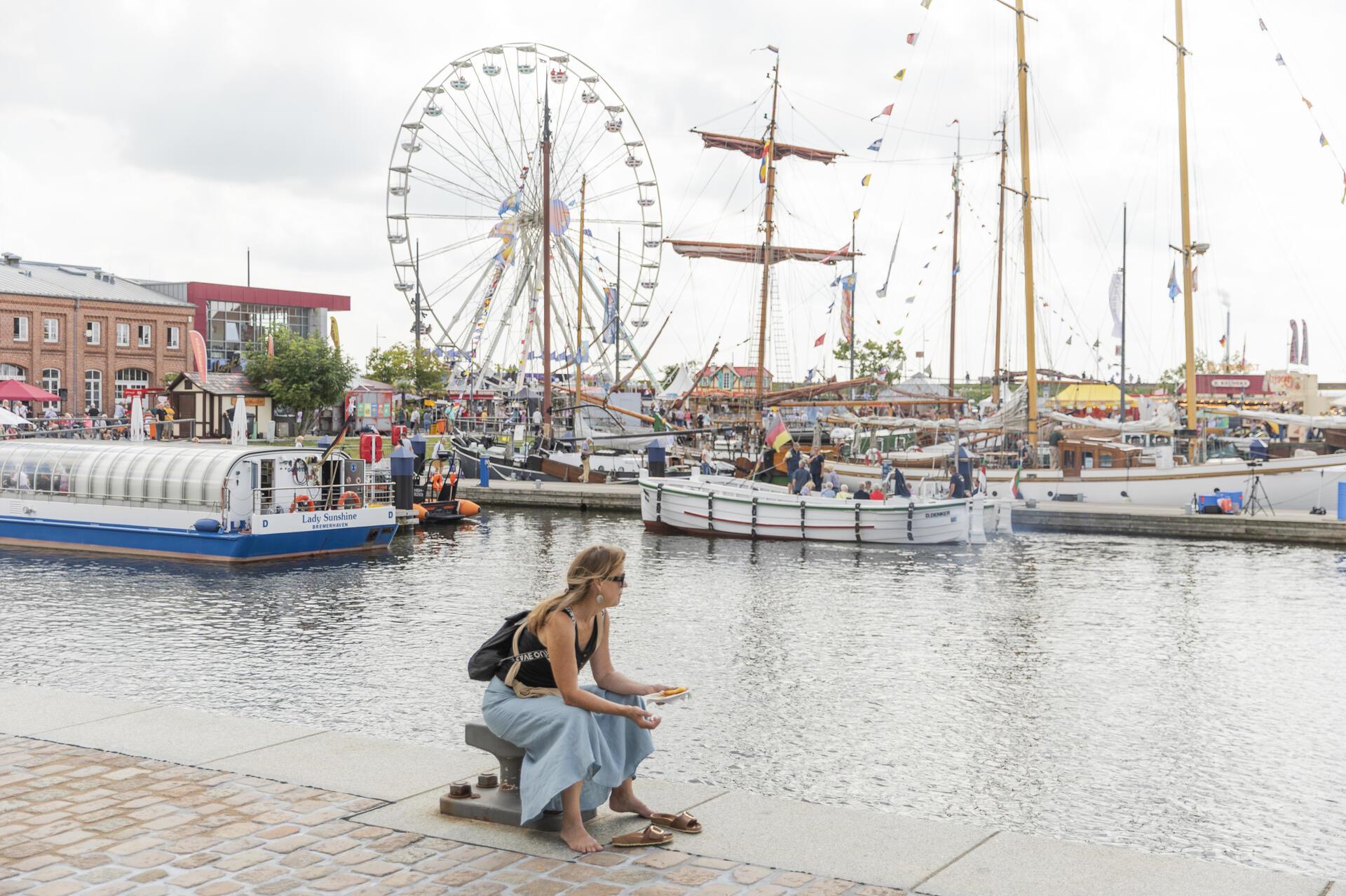 Die schönsten Eindrücke des Tages. Eine Touristin genießt ihre Pommes am Wasser.