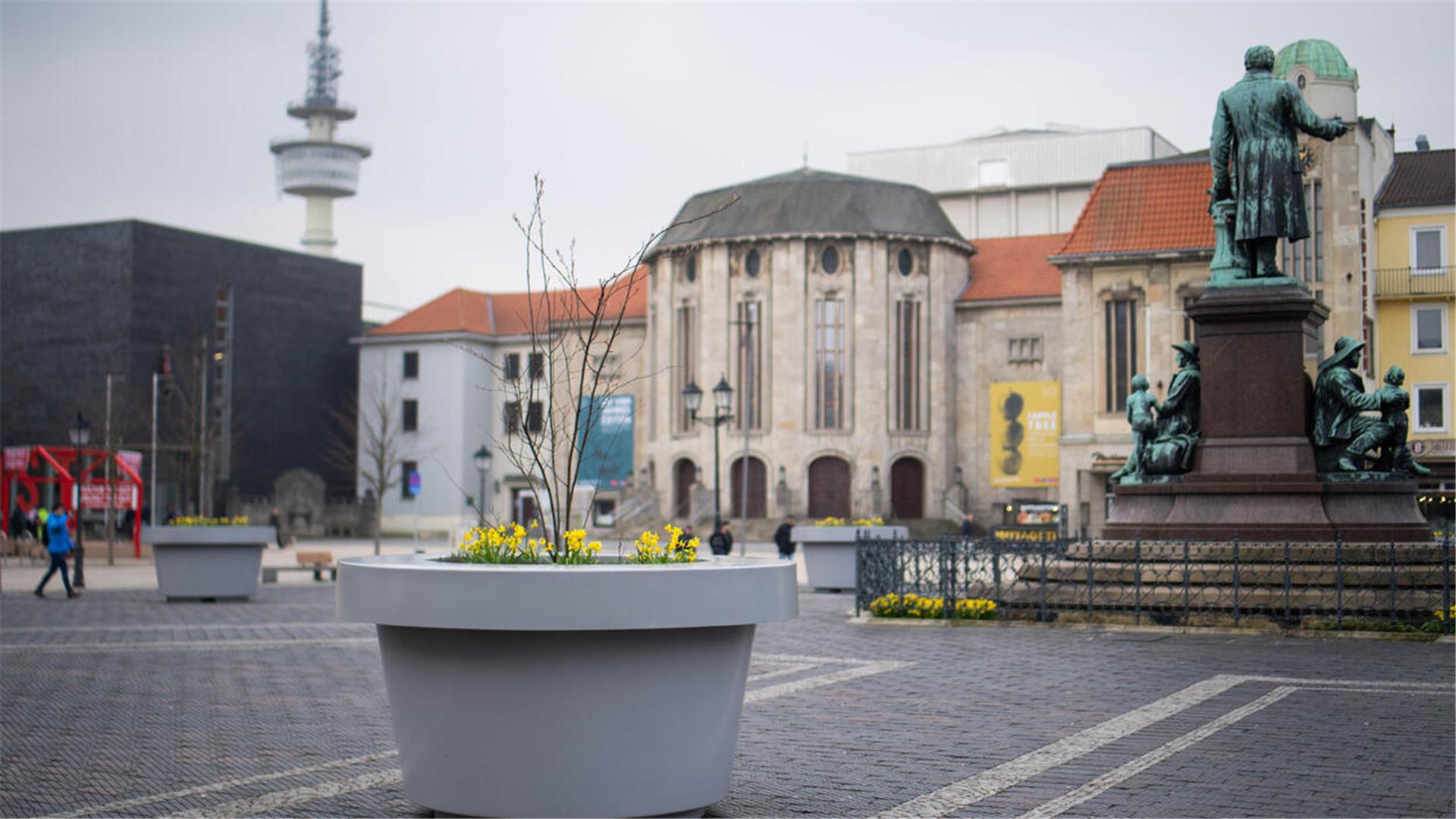 Die umstrittenen grauen XXL-Pflanzkübel „beleben“ seit Jahresbeginn 2024 den steingepflastertenTheodor-Heuss-Platz am Theater. Mit Frühlingsblüten und Bäumchen bepflanzt, sollen die „Pötte“ zur Attraktivität der Innerstadt beitragen.