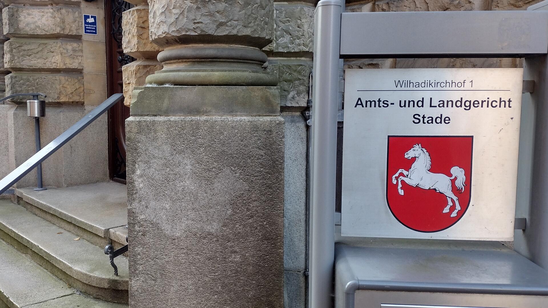 Ein Schild weist auf den Eingang des Stader Landberichts hin, im Hintergrund ist die Eingangstreppe erkennbar.