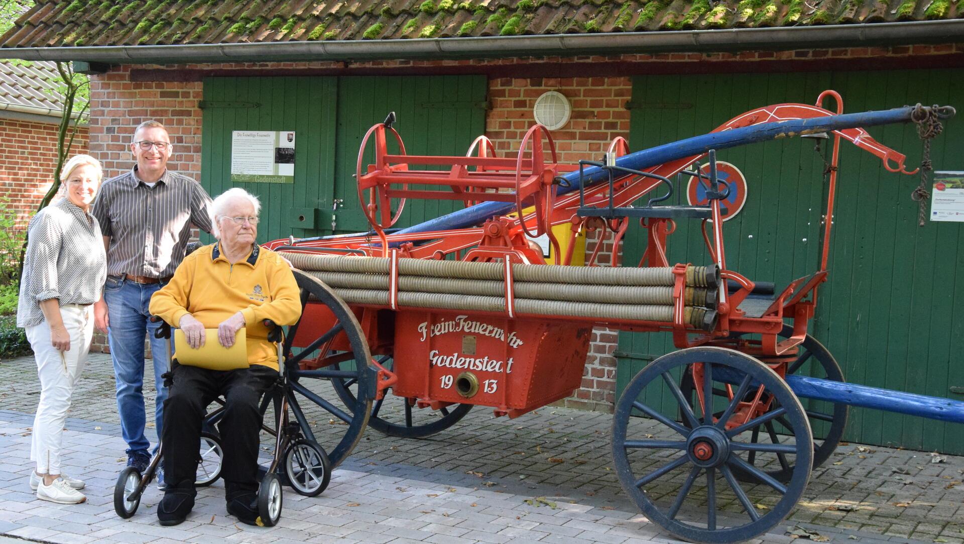 Dorfvereins-Vorsitzende Alexandra Martens (von links) und Bürgermeister Harald Hauschild freuen sich über die Übergabe der Feuerwehrspritze von 1912, die Willi Tödter vor fast 50 Jahren hat restaurieren lassen.