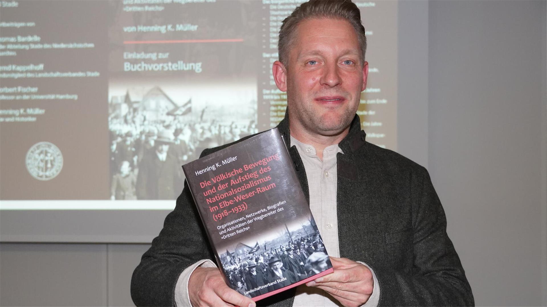 Dr. Henning Müller mit seinem Buch.