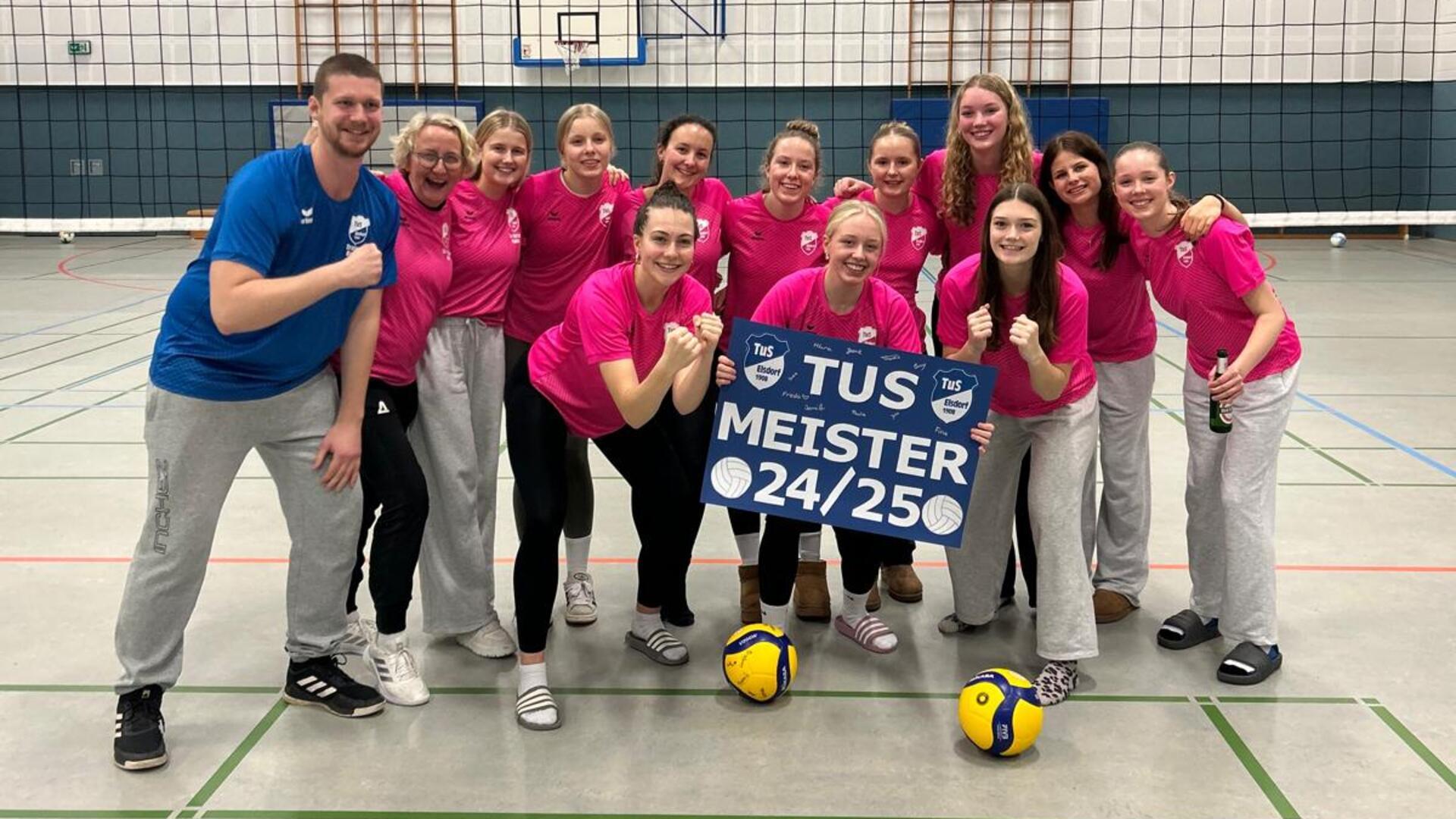 Eine Mannschaft aus jungen Frauen im pinken Shirt schaut lachend in die Kamera. 