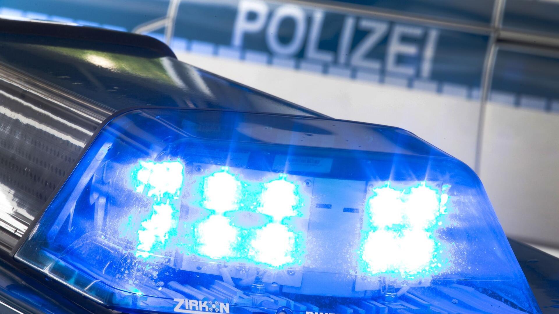 Ein Blaulicht leuchtet während eines Einsatzes auf dem Dach eines Polizeiwagens.