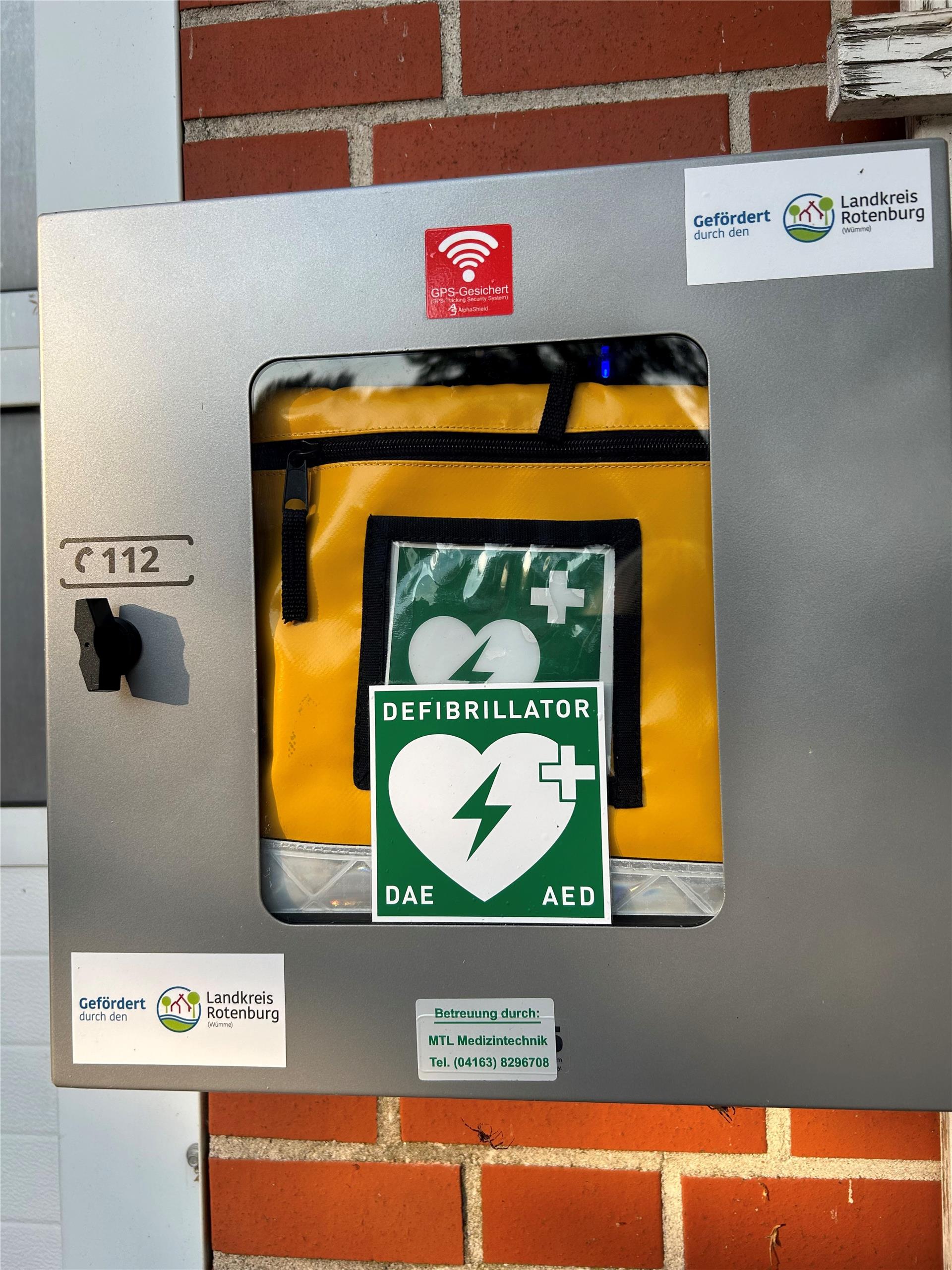 Ein Defibrillator im Kasten hängt an einer Hausfassade. In Kirchtimke und Ostertimke lernen Interessierte den richtigen Umgang mit diesen Geräten.