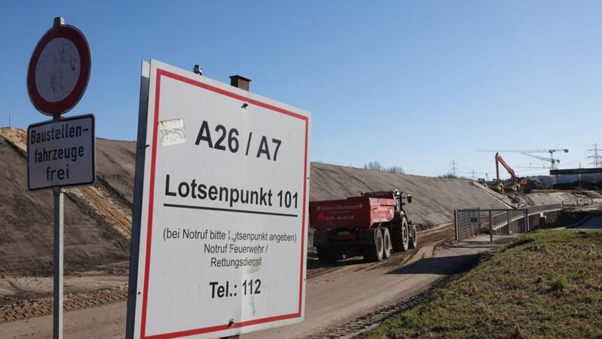 Ein Fahrzeug fährt zur Baustelle der Autobahn A26 neben der Autobahn A7.