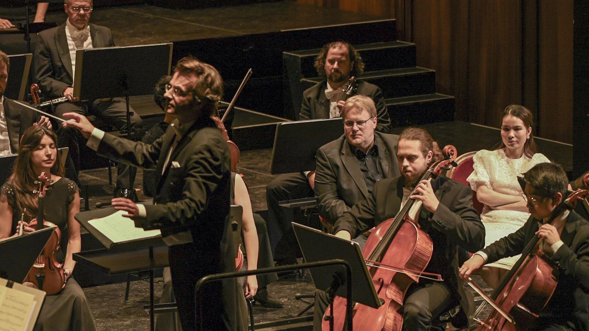 Ein Novum zum 1.Sinfoniekonzert „Neue Ufer“ des Philharmonischen Orchesters Bremerhaven: Unmittelbar neben Generalmusikdirektor Marc Niemann erleben zwei Gäste das Konzert aus neuer Perspektive mit: Sven Krause und Kim Ngan Nguyen auf ihren „heißen Stühlen“ zwischen Celli und Kontrabässen.