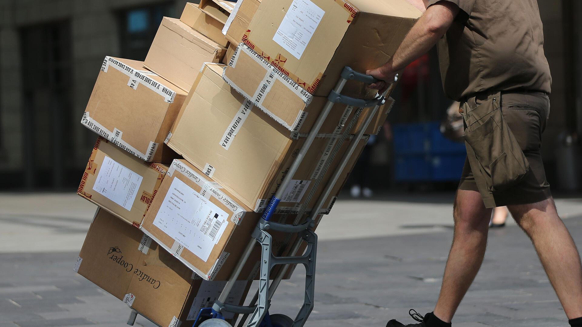 Ein Paketbote liefert Pakete aus. Bundesrat und Bundestag haben dem Postrechtsmodernisierungsgesetz zugestimmt. Dadurch verbessern sich die Arbeitsbedingungen von Paketboten.