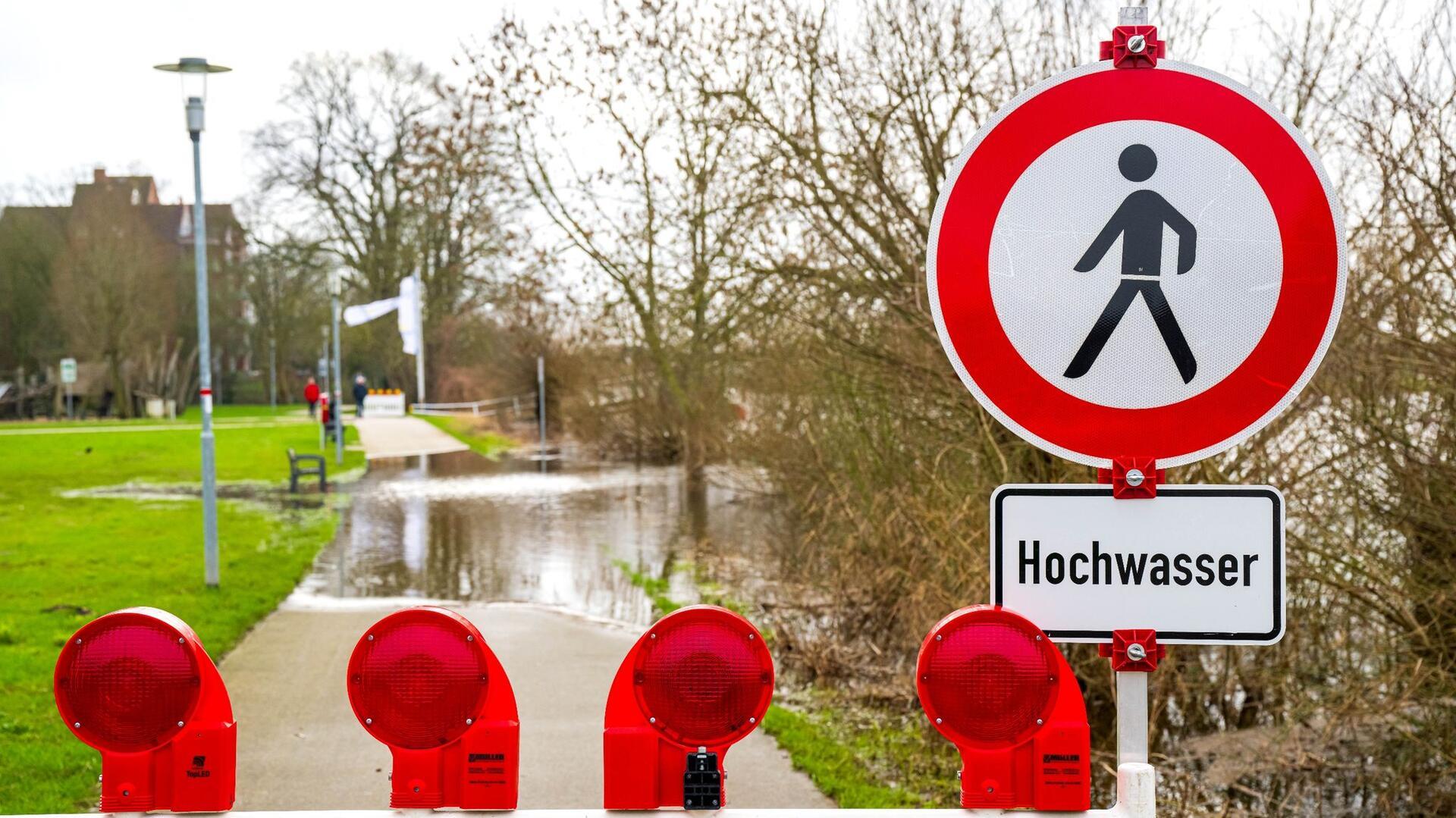 Ein Schild warnt vor dem Hochwasser, das die Aller an der Altstadt von Verden über die Ufer hat treten lassen.