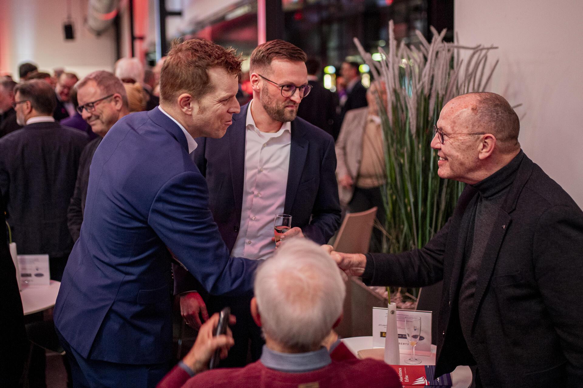 Ein freundliches Lächeln und ein Glas in der Hand – die Stimmung könnte kaum bes...